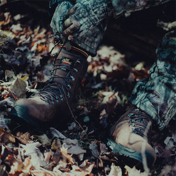 Image of Infinity FD series 9" Studhorse insulated waterproof boot on a person who is lacing up their boot