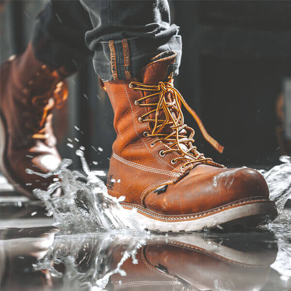 Image of American Heritage waterproof 8" tobacco composite safety toe, plain toe with Maxwear wedge boot on a person
