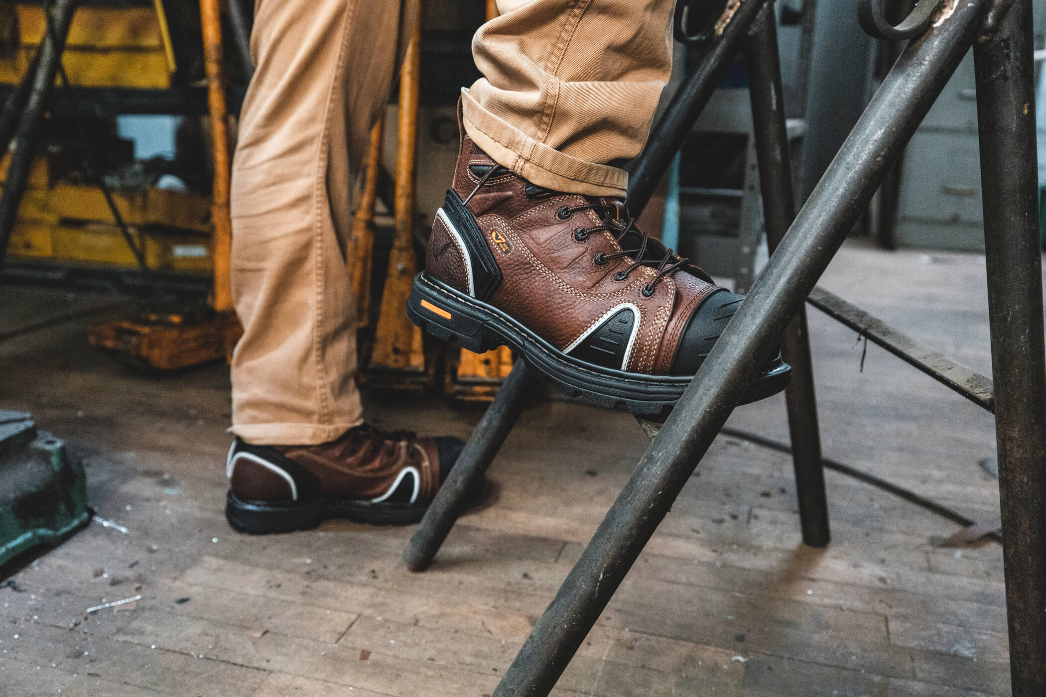 Man in work boots stepping on a ladder.