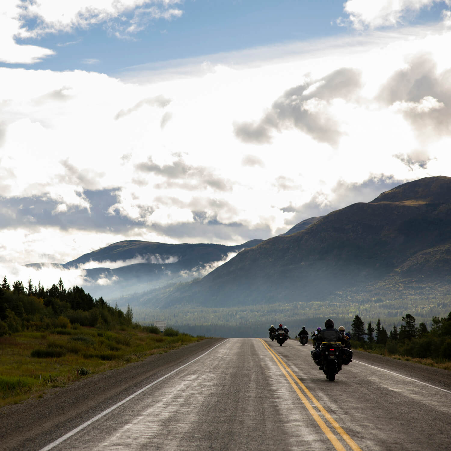Image of a group of bikers riding down an alaskan road