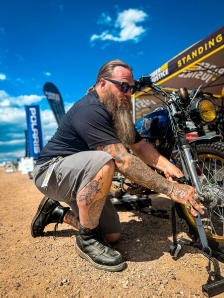 Biker wears moc toe boots to work on motorcycle.