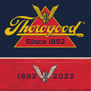 Image of the Thorogood logo on a blue background with the wing and wheel logo below it on a red background