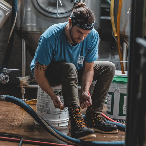 Image of 1957 series waterproof safety toe 8" Briar pitstop moc toe on a person in a brewery