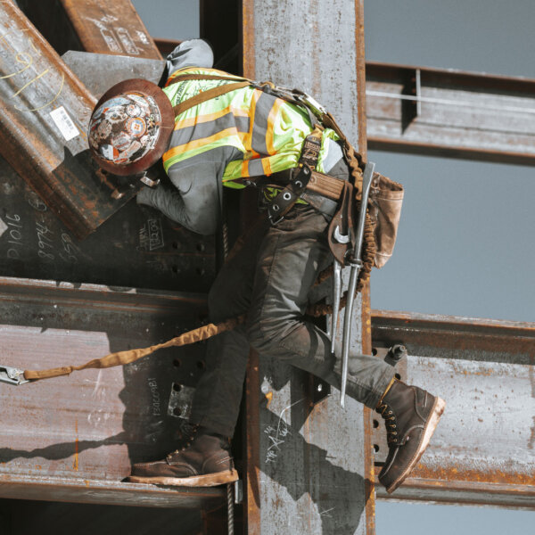 Ironworker wears non slip work shoes to climb on girders.