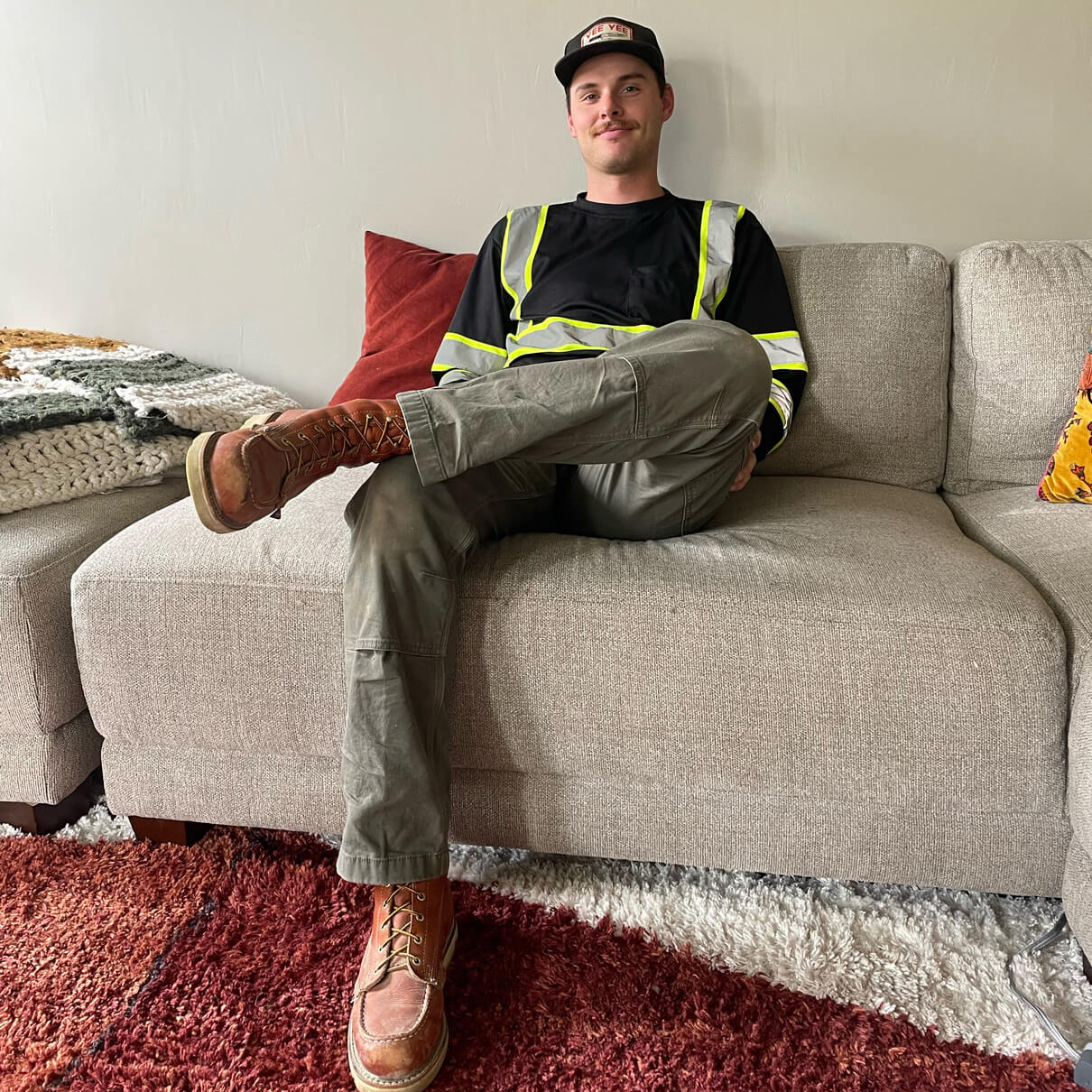 Image of a guy sitting on a couch with a safety shirt on