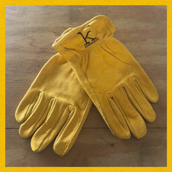 Yellow leather gloves displayed on wood